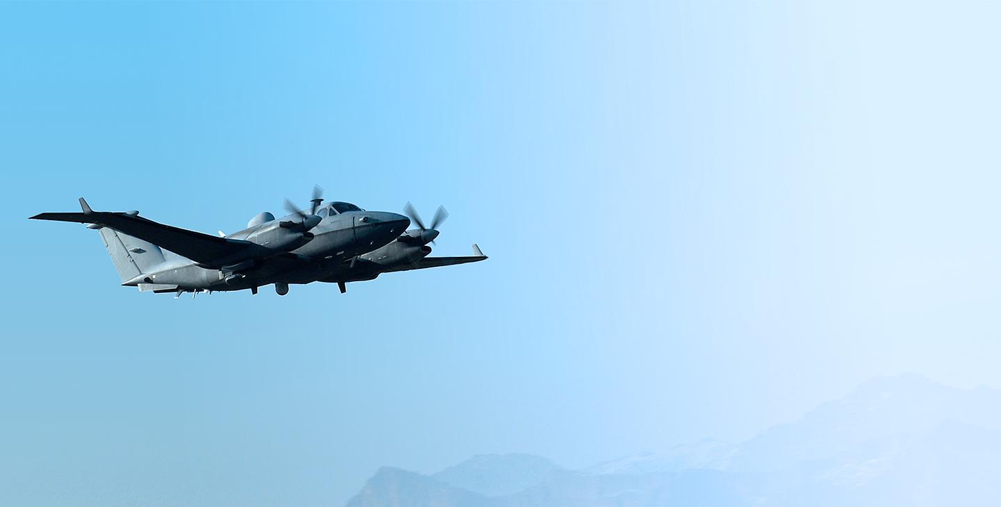 MC-12 Aircraft flying against a light blue sky